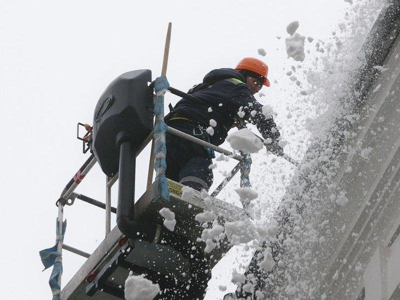 Удаление снега с крыши с автовышки в Тюмени