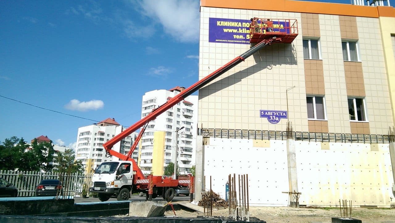 Изображение монтажа рекламы с помощью автовышки